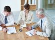 Business people, boardroom and signature on paperwork in meeting or lawyer agreement, partnership or negotiation. Men, woman and document in corporate office for collaboration, consultant or contract.